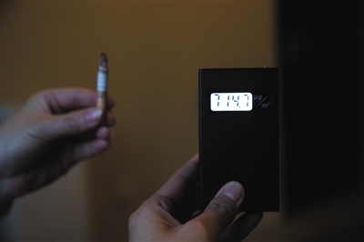 点燃一支烟后,PM2.5升至714.7ug/m3。新京报记者 薛珺 摄